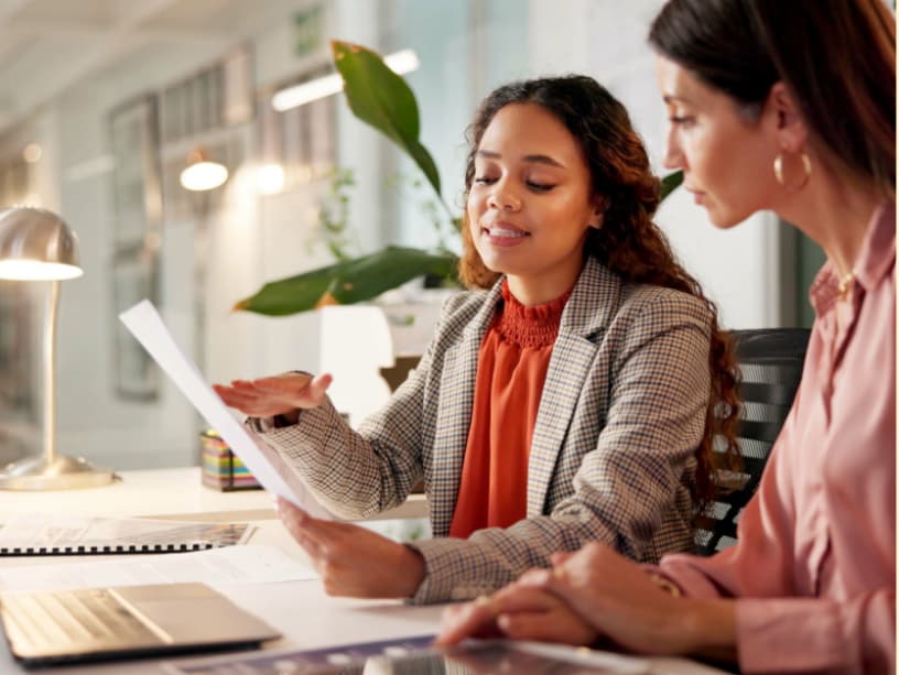 B2B account manager reviewing marketing performance report with a client, demonstrating proactive communication and client retention strategy