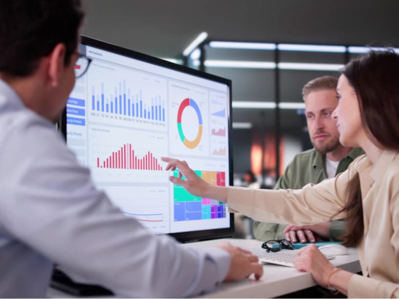 Marketing and sales team reviewing a unified analytics dashboard, illustrating clear data visibility and alignment across departments for better decision-making.