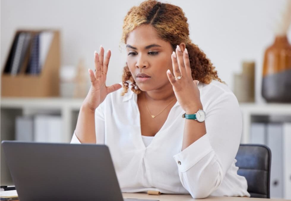 Person frustrated by messy CRM data and duplicate records while reviewing contacts on a laptop.