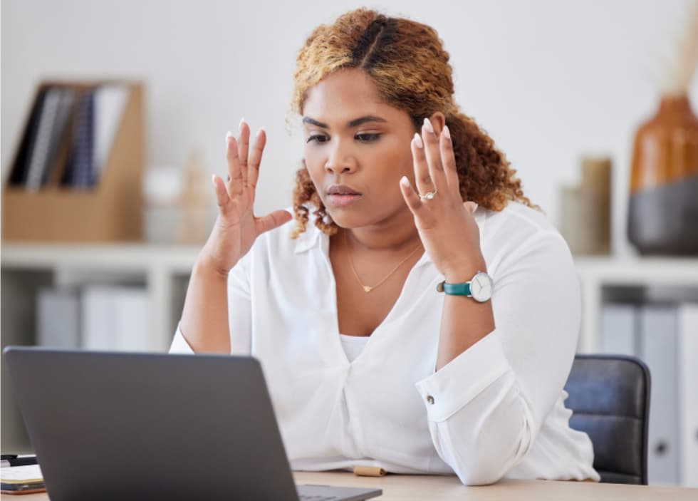 Person frustrated by messy CRM data and duplicate records while reviewing contacts on a laptop.